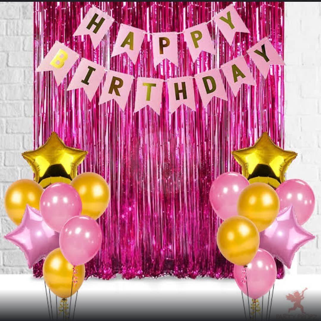 Fringe backdrop with a birthday banner and colorful balloons.