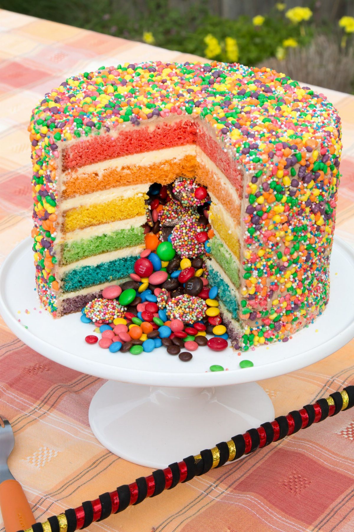 Rainbow layer cake with colorful layers and candy inside.