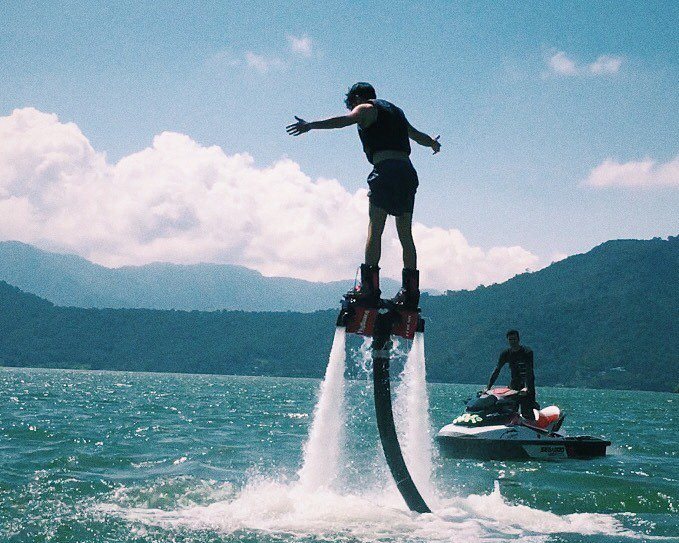 Person flyboarding over water with jets of water spraying.