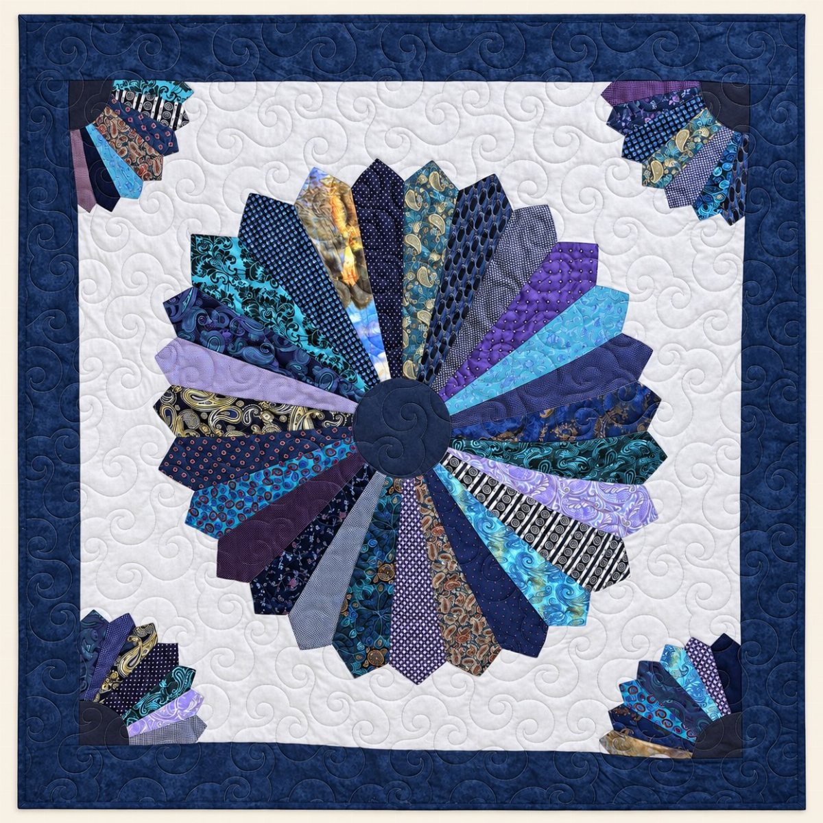 A blue and purple patterned fabric quilt with a large central sunburst design.