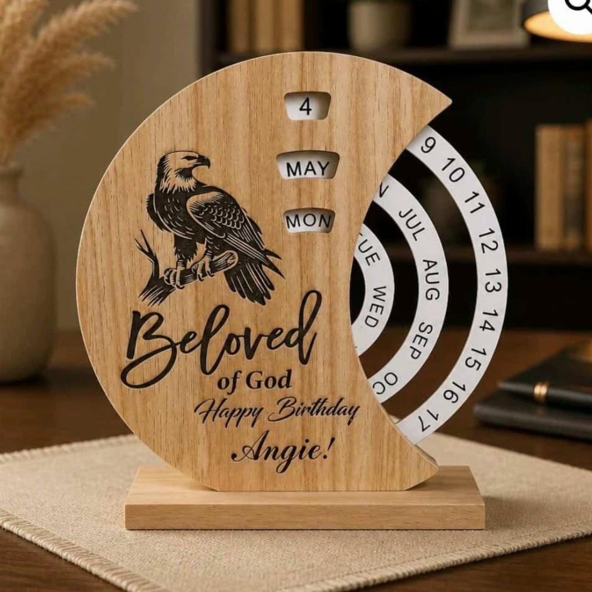 A wooden crescent moon perpetual calendar engraved with an eagle and a personalized birthday message.