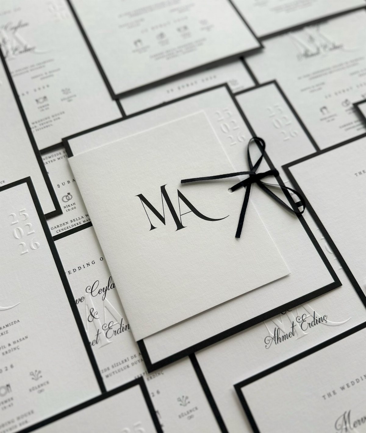13 Black and White Wedding Decor Ideas for an Elegant Celebration 13 White wedding invitations with black borders and a central monogram tied with a black ribbon.