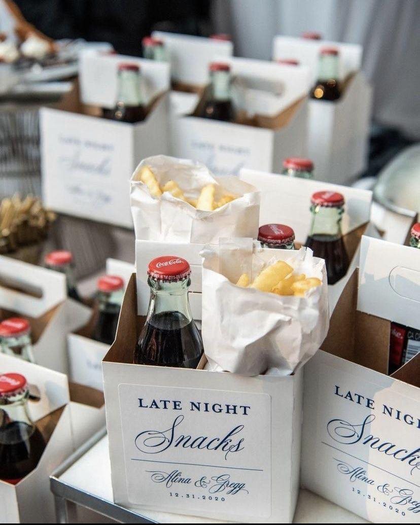 White snack boxes filled with french fries in paper bags and glass cola bottles.
