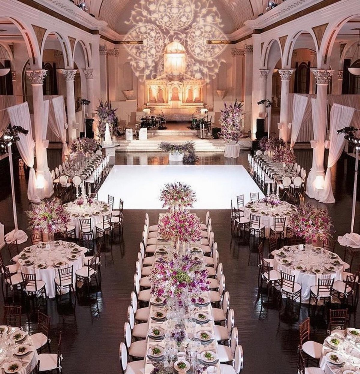 Elegant ballroom setup with long rectangular and round dining tables arranged around a central dance floor.