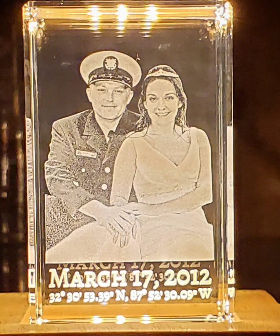 Laser-etched 3D crystal block displaying a couple's portrait and their wedding date and coordinates.