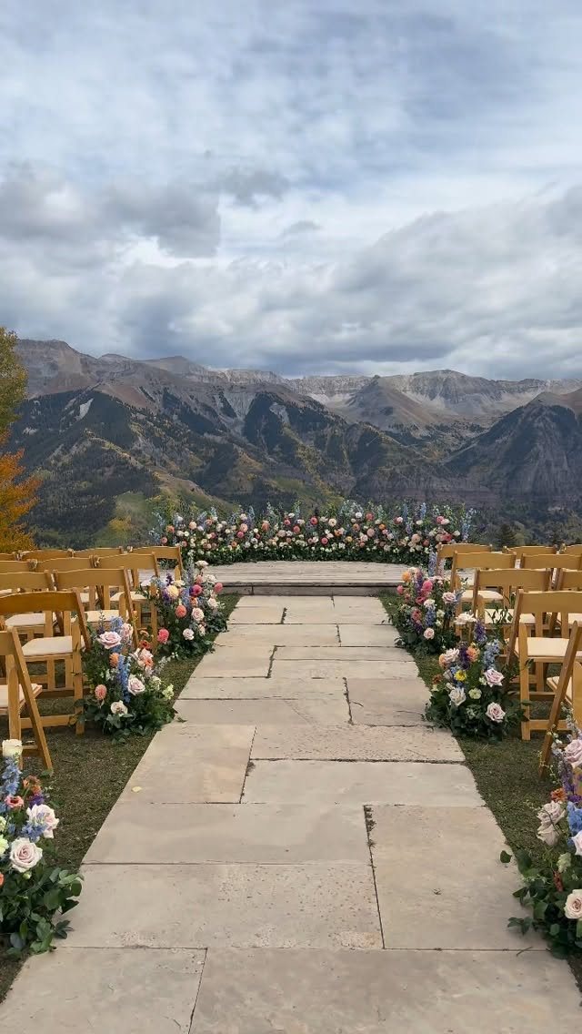 Stone pathway leading to a wedding ceremony setup with mountains in the background.