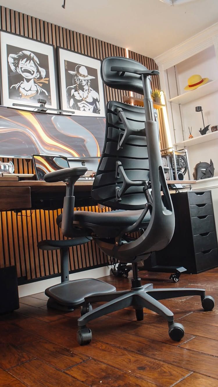 20 Bedroom Office Ideas for Small Spaces and Dual-Purpose Rooms 19 Black ergonomic office chair positioned in front of a wooden desk and slatted wall.