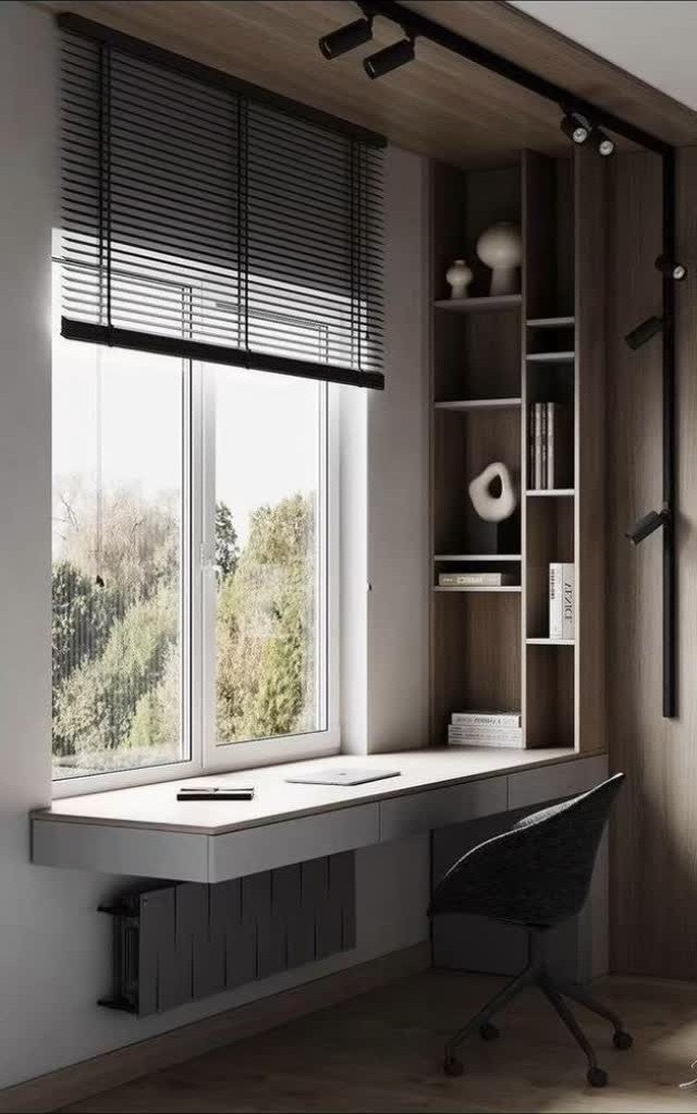 20 Bedroom Office Ideas for Small Spaces and Dual-Purpose Rooms 9 A long white desk positioned in front of a large window overlooking trees with built-in shelving.