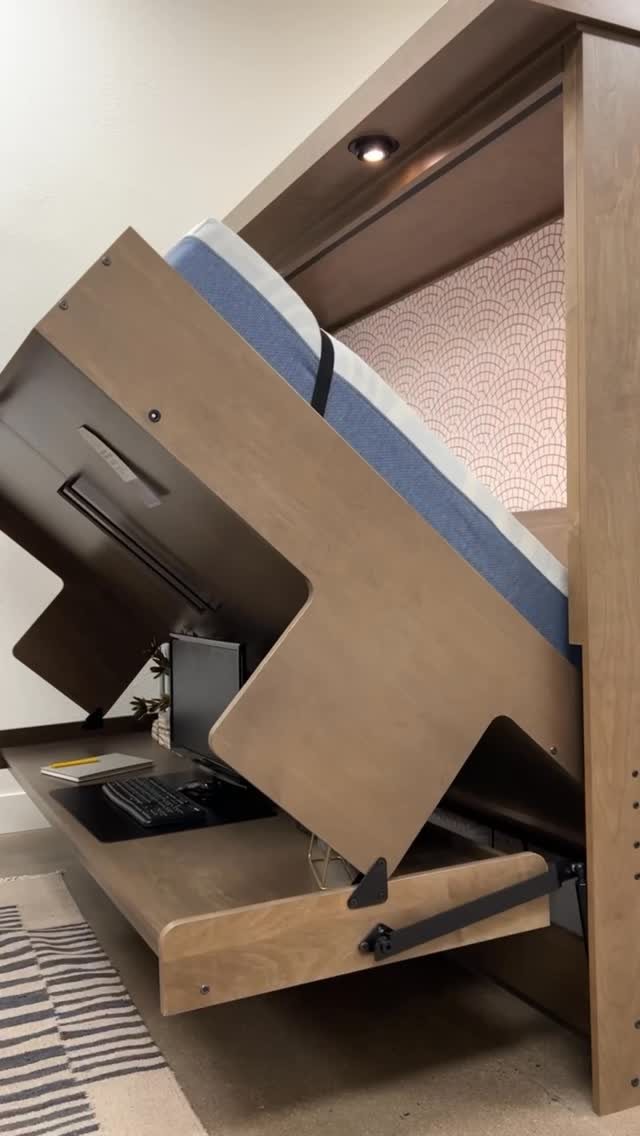 20 Bedroom Office Ideas for Small Spaces and Dual-Purpose Rooms 4 A wooden Murphy bed partially lowered to reveal a built-in desk with a computer setup.