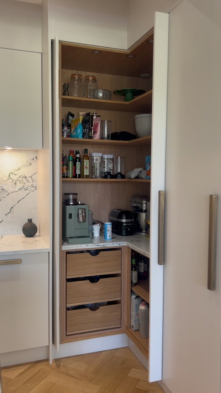 8 Corner Cabinet Ideas for Kitchens That Actually Work 7 An open tall corner cabinet with wooden shelves filled with various kitchen supplies and appliances.