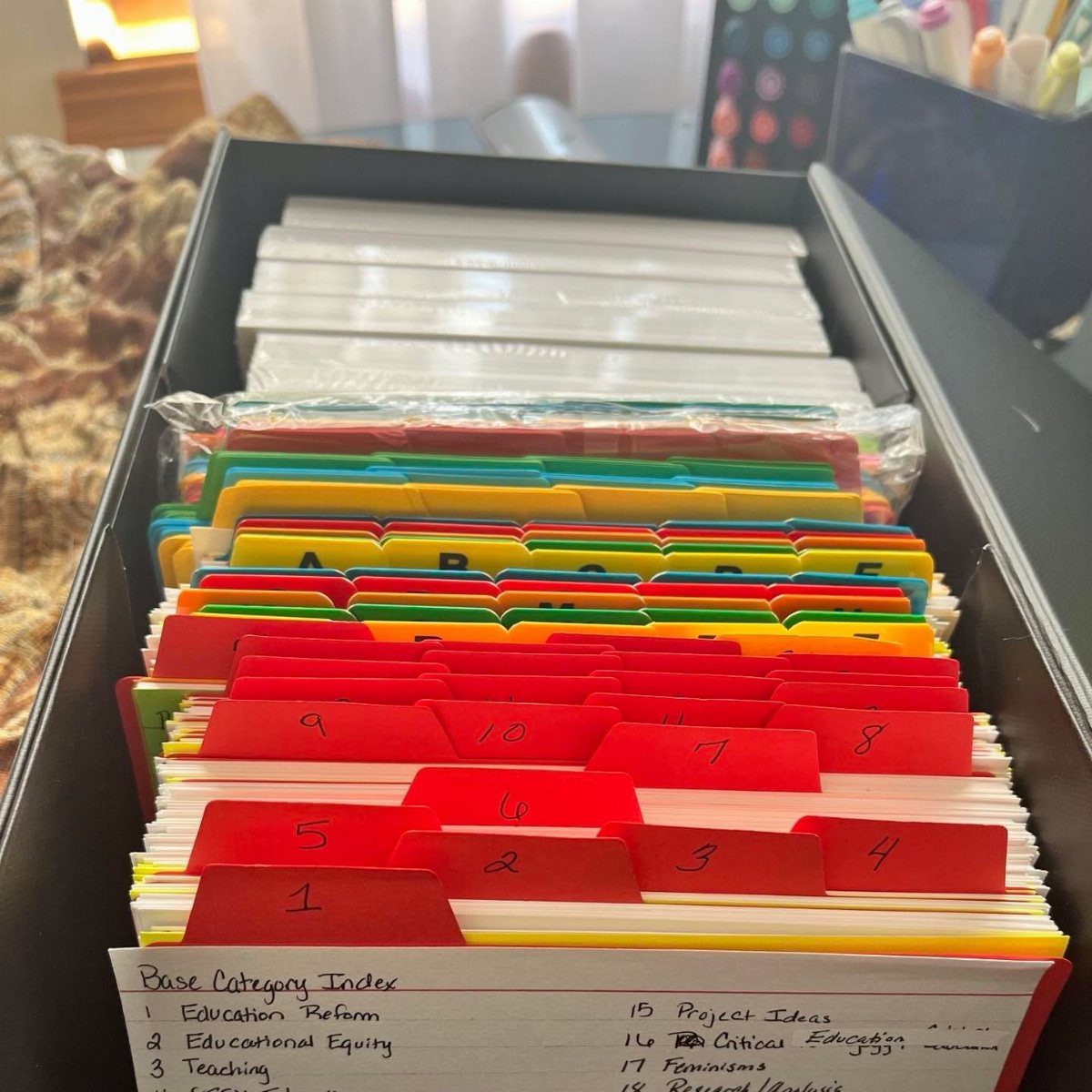 11 Desk Organization Ideas That Tidy Your Space for 2026 9 Organized file folders with red numbered tabs inside a black desk drawer.
