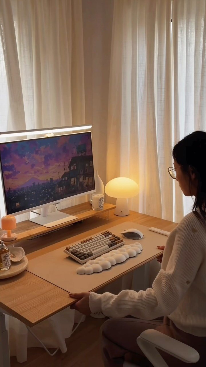 11 Desk Organization Ideas That Tidy Your Space for 2026 2 A person sitting at a clean, organized wooden desk with a computer and warm lighting.