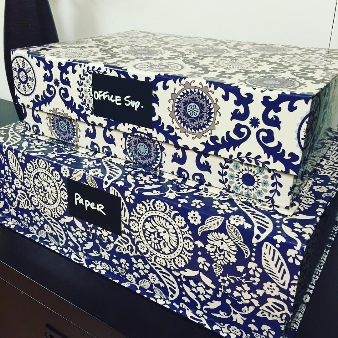 11 Desk Organization Ideas That Tidy Your Space for 2026 1 Two blue and white patterned storage boxes with handwritten labels for office supplies and paper.