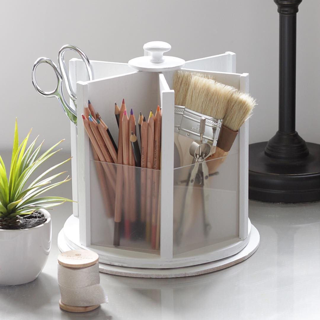 11 Desk Organization Ideas That Tidy Your Space for 2026 10 White rotating desk organizer holding pencils, scissors, and paintbrushes on a light desk surface.
