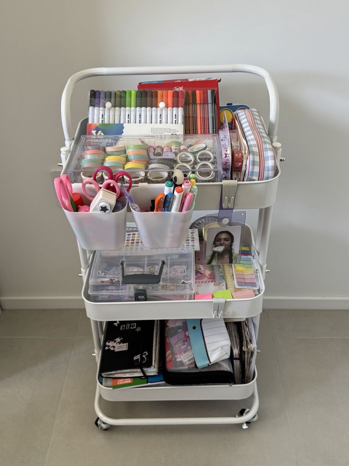11 Desk Organization Ideas That Tidy Your Space for 2026 7 A white three-tier rolling cart organized with colorful markers, pens, tapes, and various stationery supplies.