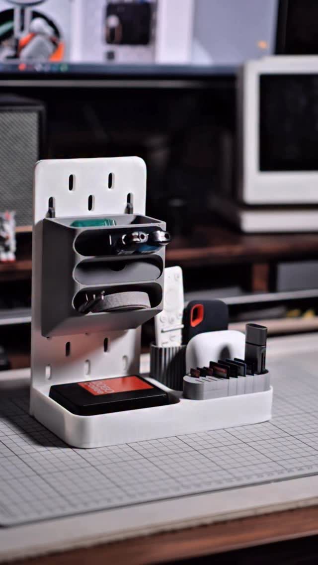 11 Desk Organization Ideas That Tidy Your Space for 2026 4 White plastic desk organizer holding pens, tape, and small tools on a grey grid mat.