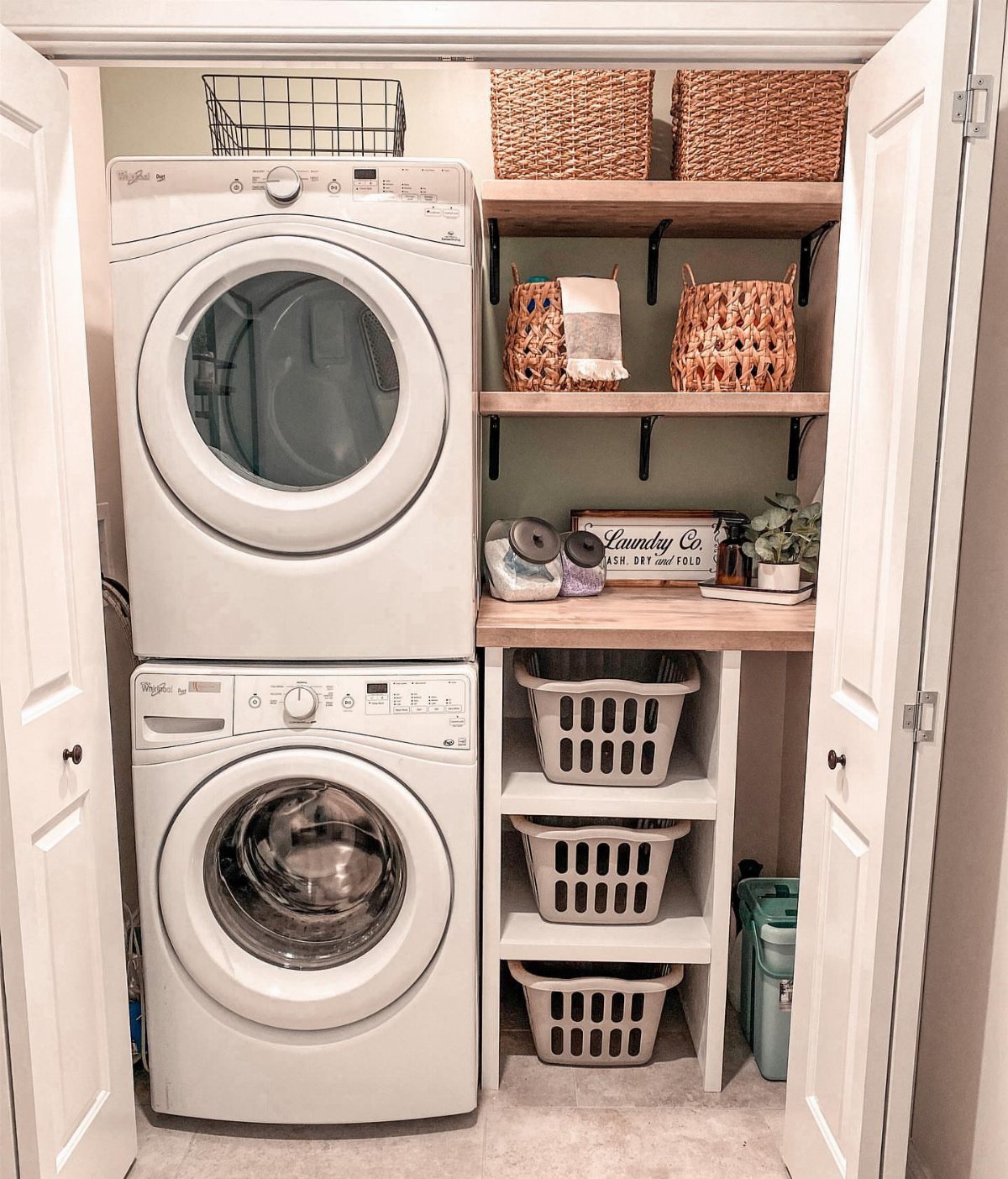 17 Laundry Room Ideas for Storage, Style and Smarter Layouts 16 Stacked white washer and dryer next to organized shelving inside a small laundry closet.