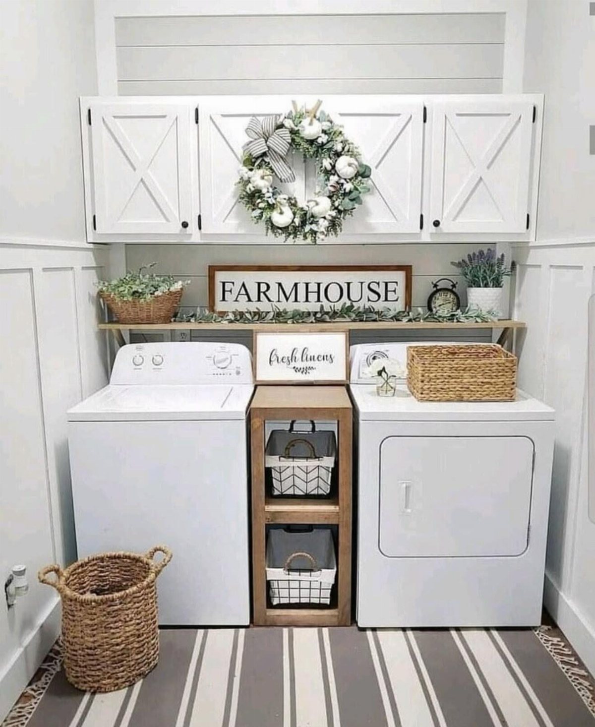 17 Laundry Room Ideas for Storage, Style and Smarter Layouts 5 White laundry room with decorative wreath, farmhouse sign, plants, and striped rug.