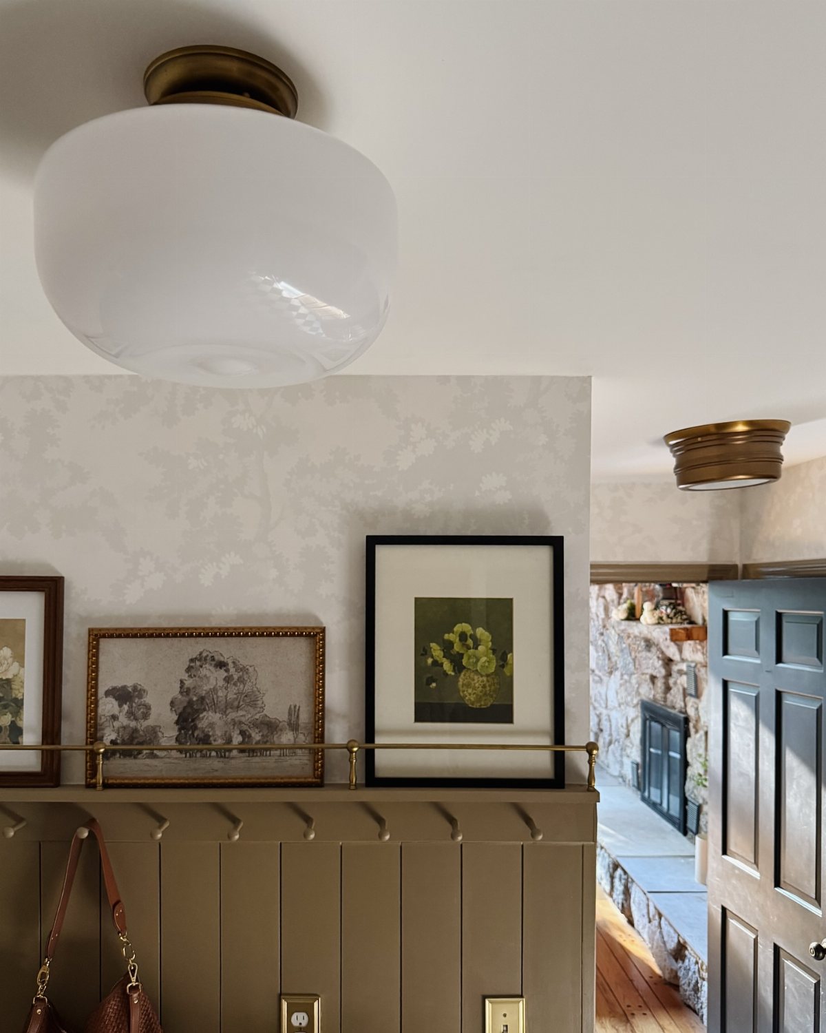 17 Mudroom Ideas for Entryways That Actually Work in 2026 14 Two frosted glass dome light fixtures mounted on a white ceiling above a decorated wall.