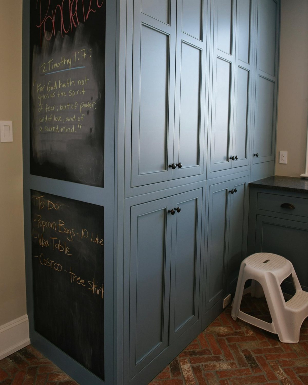17 Mudroom Ideas for Entryways That Actually Work in 2026 6 Blue built-in cabinets with two large chalkboard panels displaying handwritten notes and lists.