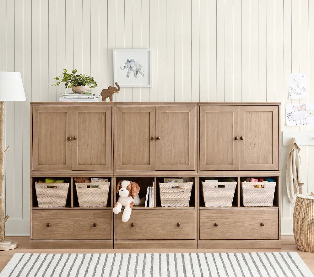 7 Toy Organization Ideas for Playrooms and Living Spaces 3 Wooden storage unit with cubbies containing woven baskets filled with toys and a stuffed animal.