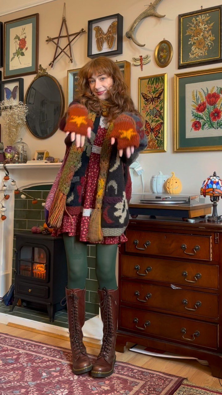 A woman wearing a patterned cardigan, green leggings, and brown lace-up boots standing in a room.