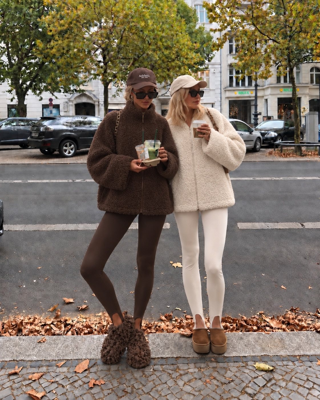 Two women standing on a sidewalk wearing fuzzy jackets and leggings during autumn.