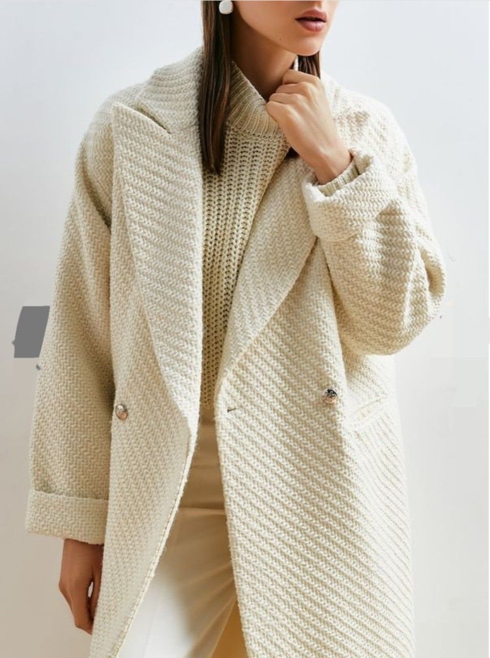 Woman wearing a textured off-white knitted wool-blend coat with a wide collar.