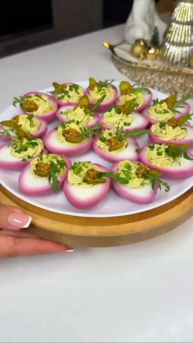 Dyed Deviled Eggs: 5 Ways From Pastel to Bright Pink 3 Pink dyed deviled eggs topped with herbs and pickles on a white plate.