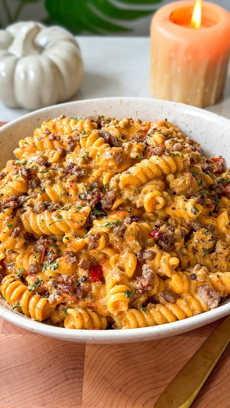 14 Ground Beef Recipes Using Few Ingredients for Low-Stress Weeknights 4 Rotini pasta mixed with ground beef and melted cheese in a white bowl on a wooden surface.