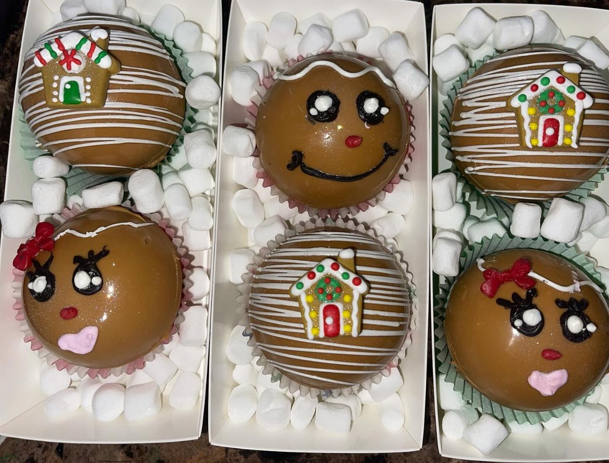 12 Hot Chocolate Bombs for Every Holiday and Skill Level 8 Decorated chocolate spheres with gingerbread designs resting in white boxes filled with mini marshmallows.