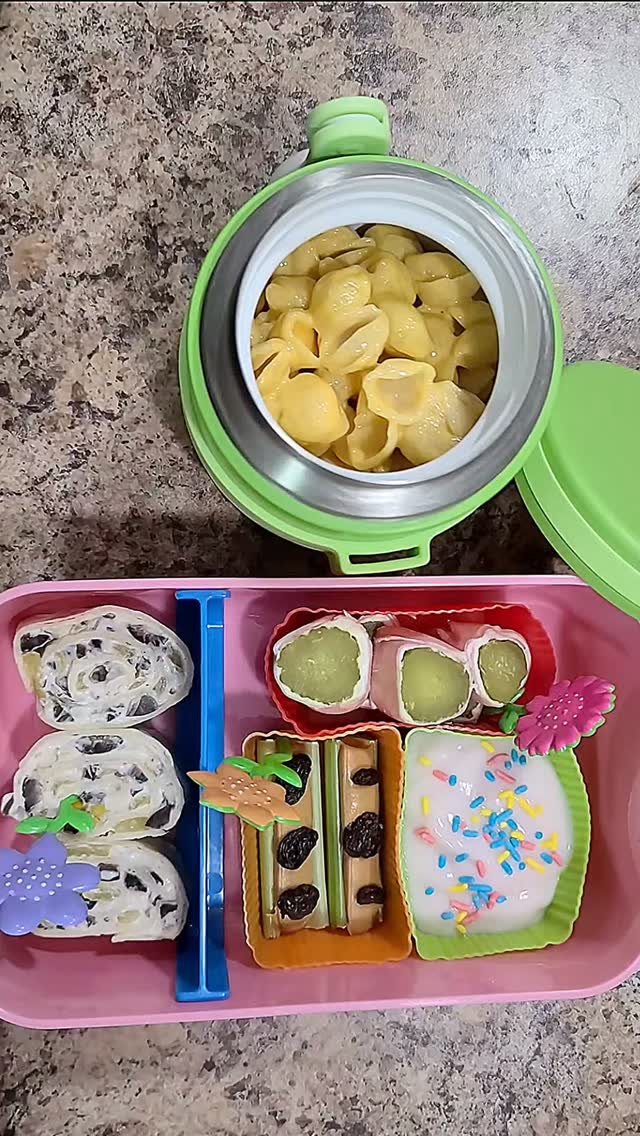 19 School Lunch Ideas for Real Mornings 19 A pink bento box filled with pinwheel sandwiches, celery ants on a log, and yogurt with sprinkles.