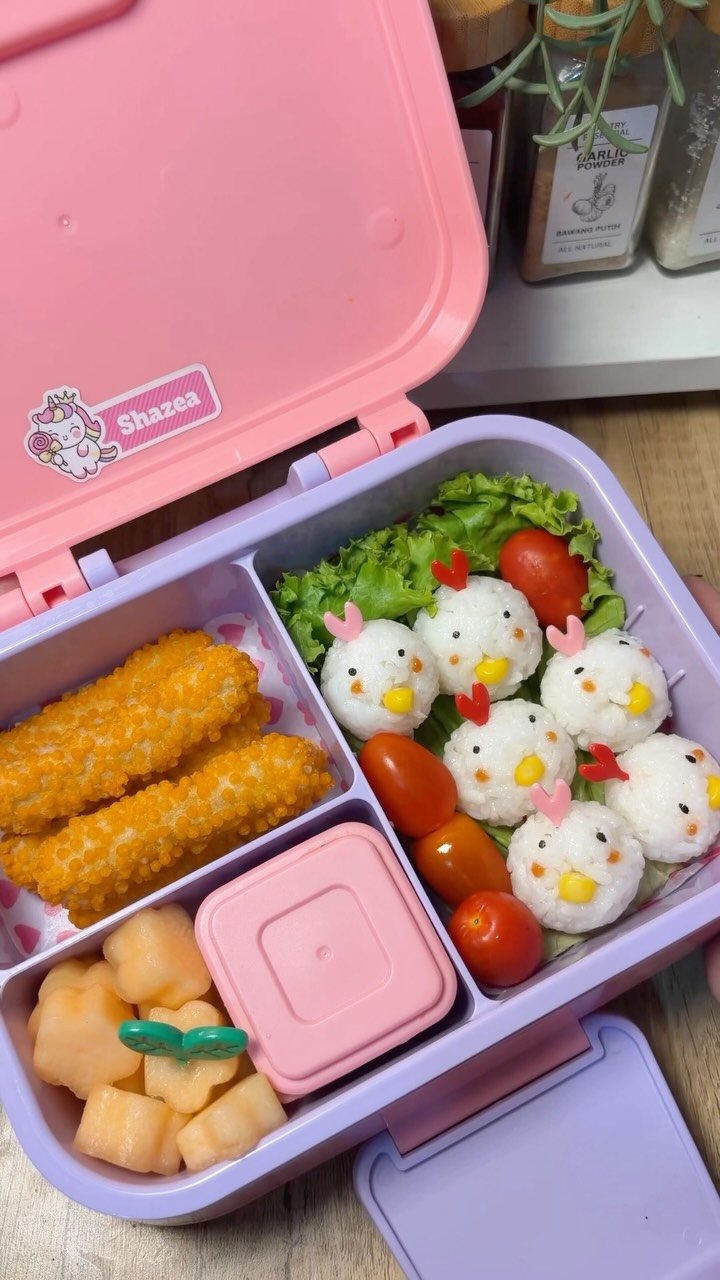 19 School Lunch Ideas for Real Mornings 16 Chicken-shaped rice balls, tomatoes, and nuggets inside a purple bento lunch box.