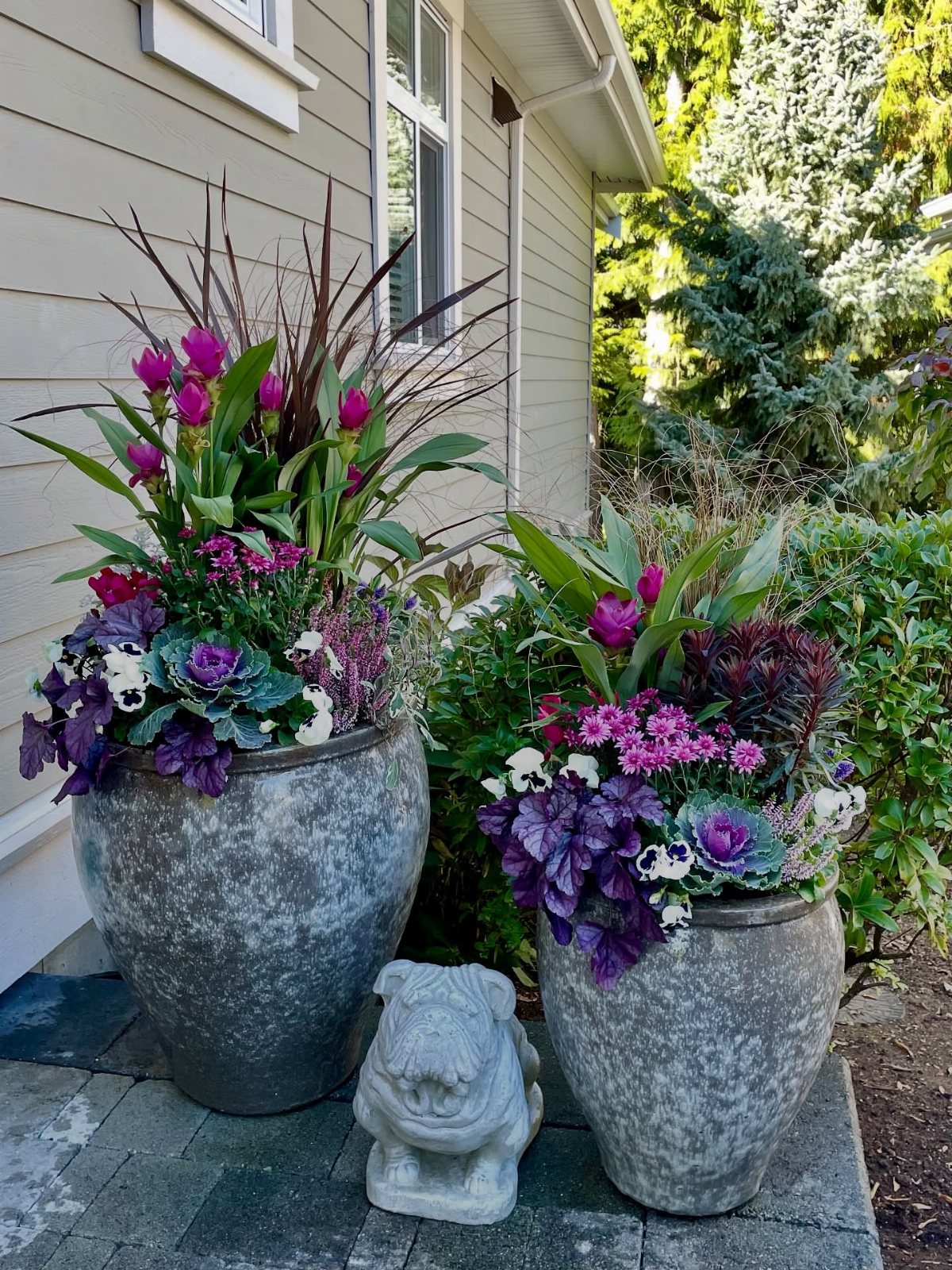 Fall Planter Ideas: 12 Container Combos for Color, Foliage and Texture 3 Two large stone urns filled with layered purple cabbage, pink flowers, and tall grasses on a patio.