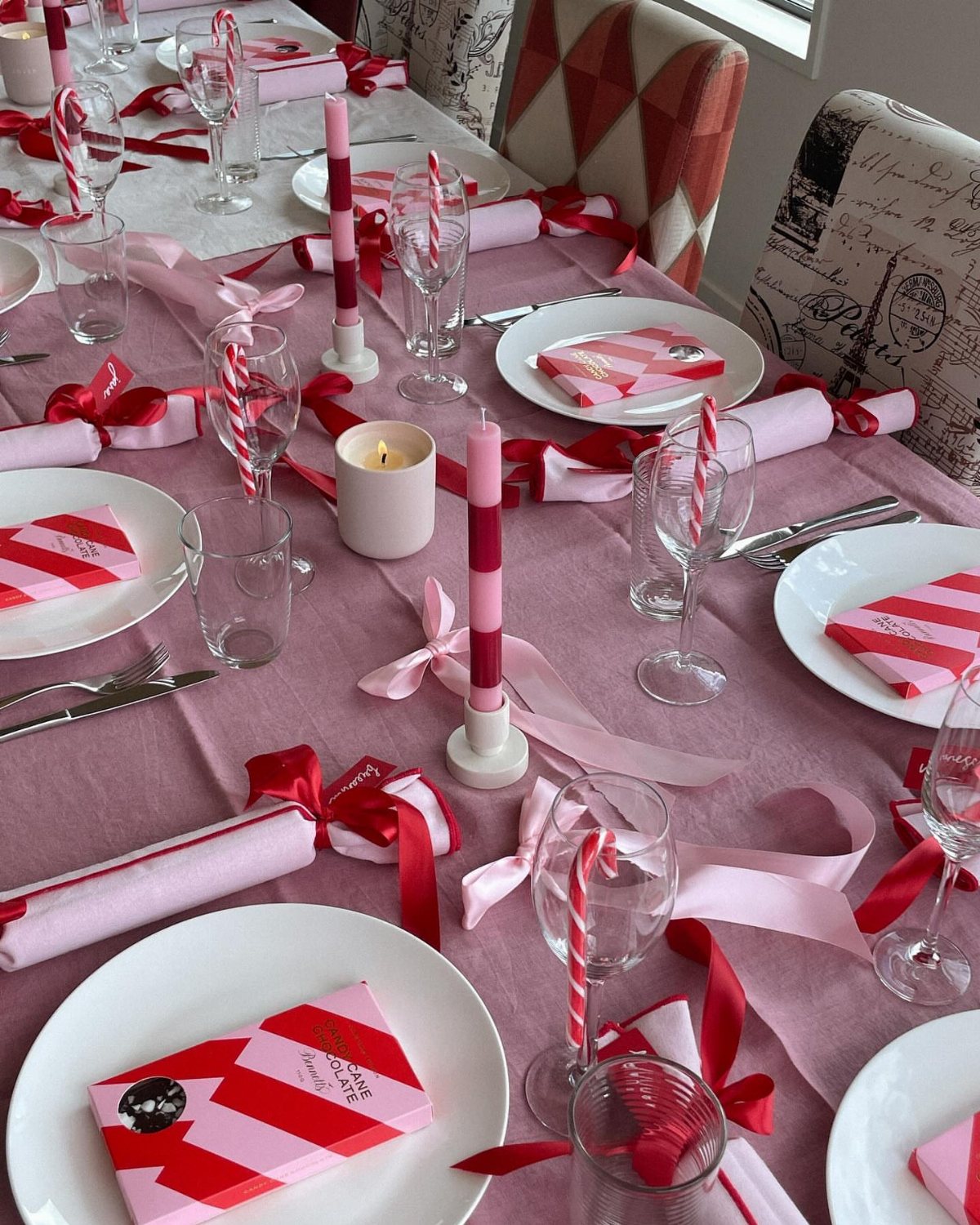 Candy Cane Themed Party: 9 Ideas for Decor and Desserts 3 A festive dining table set with pink linens, striped napkins, candles, and red and pink ribbons.