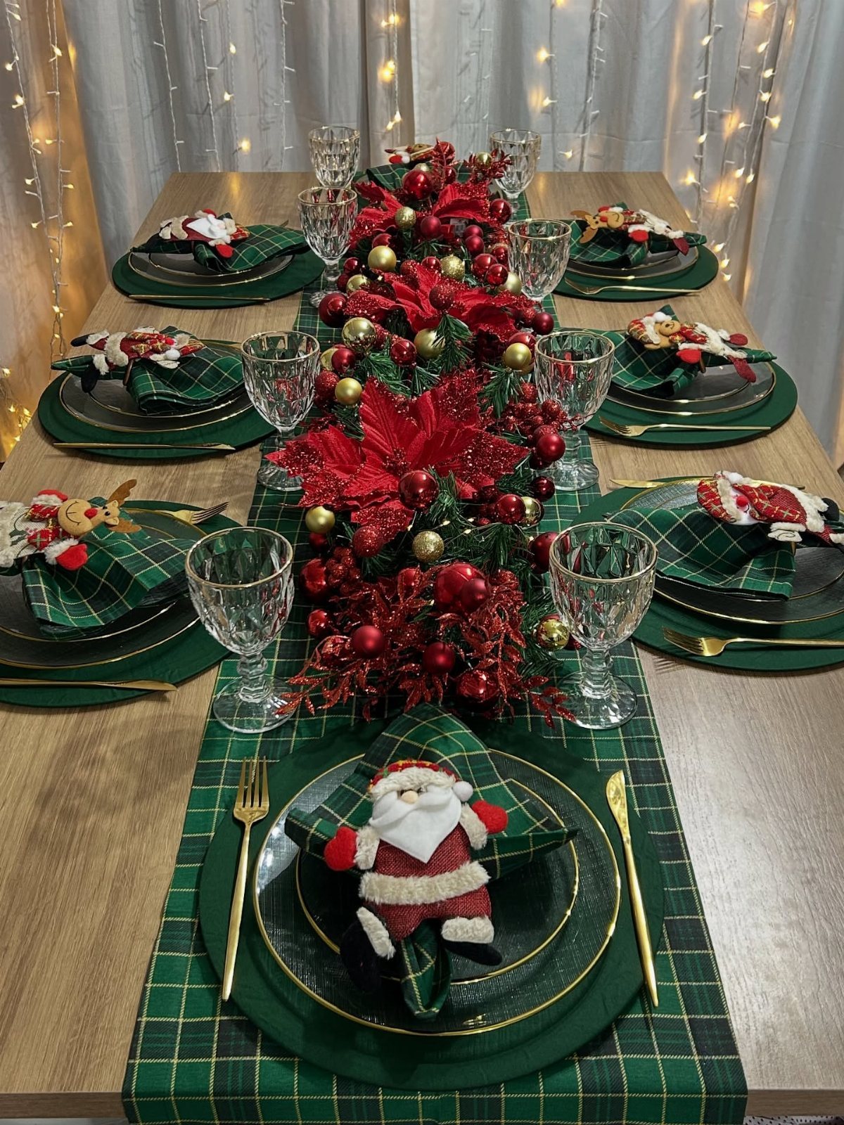 Christmas Table Place Setting Ideas: 16 Styles to Try 6 Christmas table setting with green plaid placemats, dark green plates, and a red floral garland centerpiece.