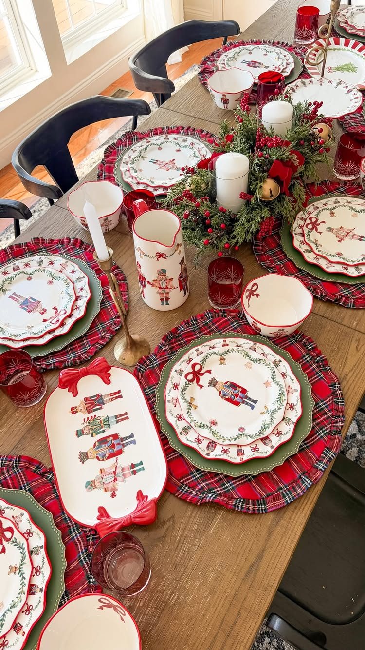 Christmas Table Place Setting Ideas: 16 Styles to Try 13 Christmas table setting with nutcracker themed plates, plaid placemats, and an evergreen centerpiece on a wooden table.