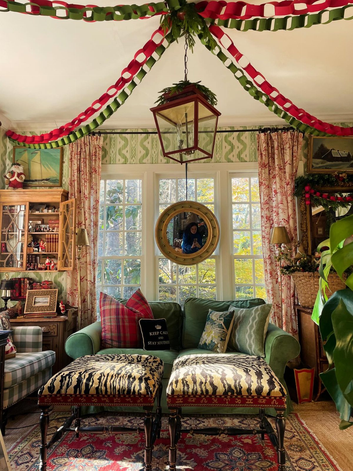 14 Decorating Cheap for Christmas Ideas for 2026 4 Red and green paper chains draped across a decorated living room ceiling.