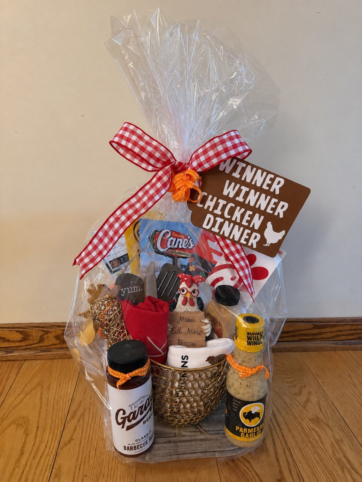 A gift basket filled with food items and a winner winner chicken dinner sign.