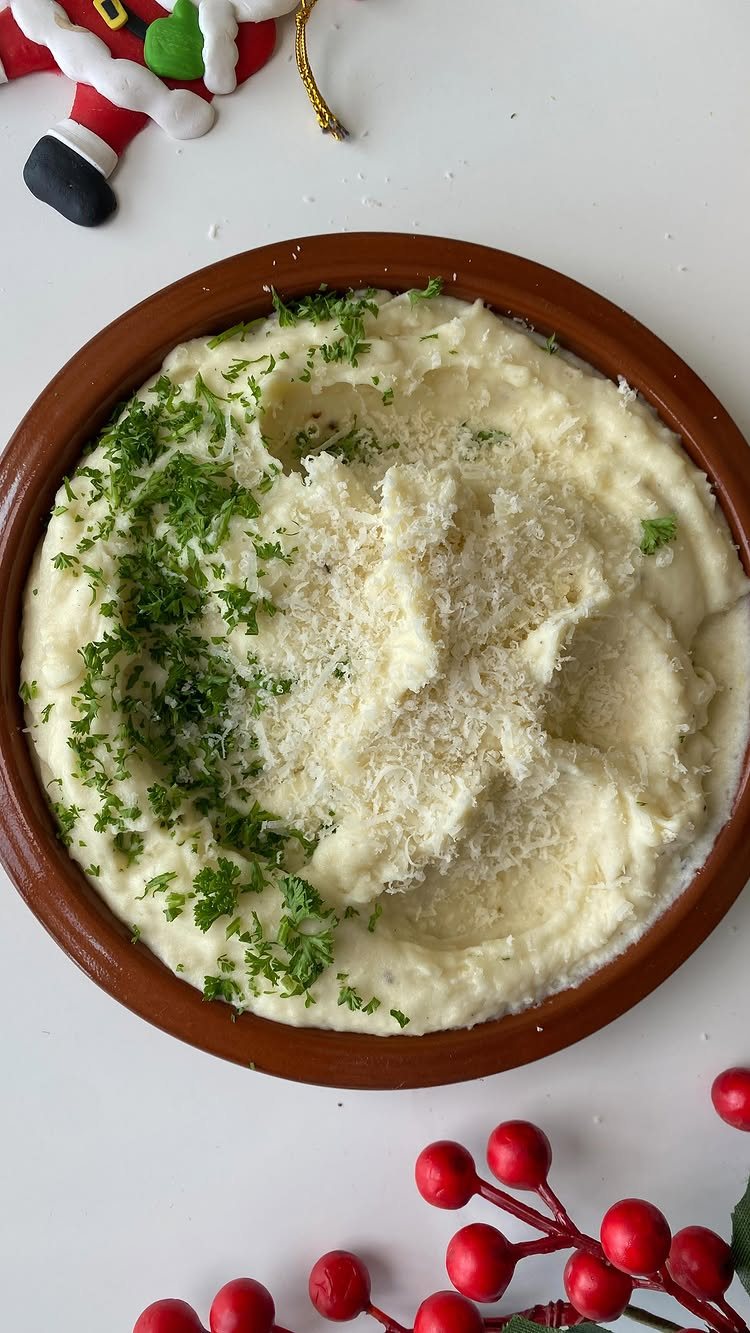 28 Easy Christmas Eve Dinner Ideas: From Slow Cooker Ham to Wreath Pizza 15 Creamy mashed potatoes topped with green parsley and parmesan cheese in a brown bowl.