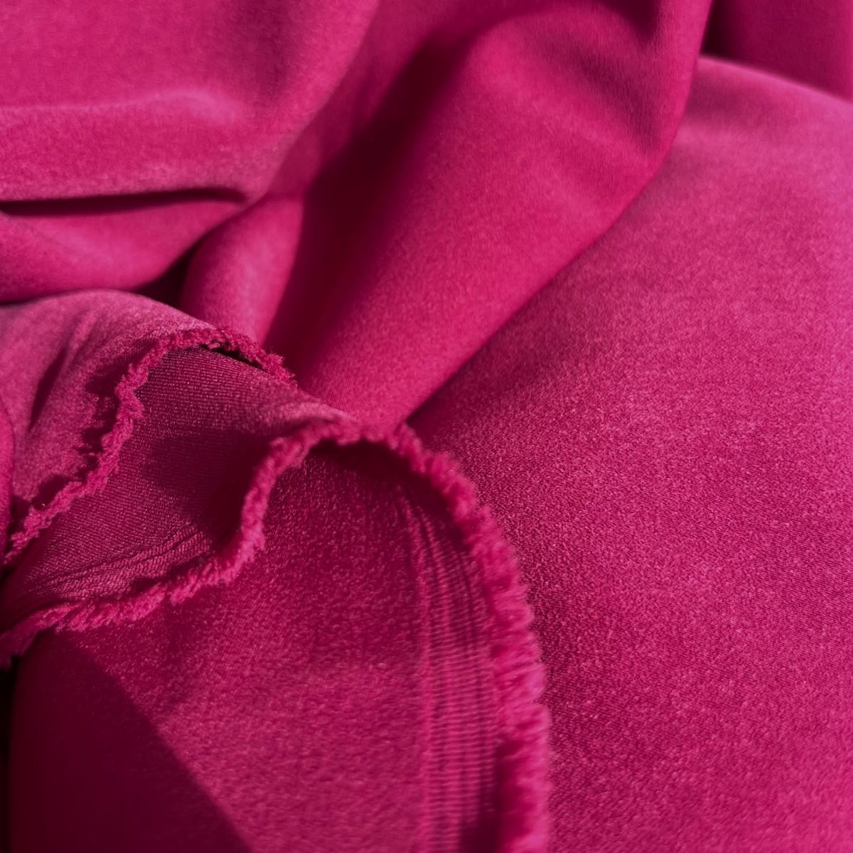 9 Hot Pink Background Ideas for Phones and Walls 9 Hot pink fabric with soft folds and frayed edges shown in a close-up view.