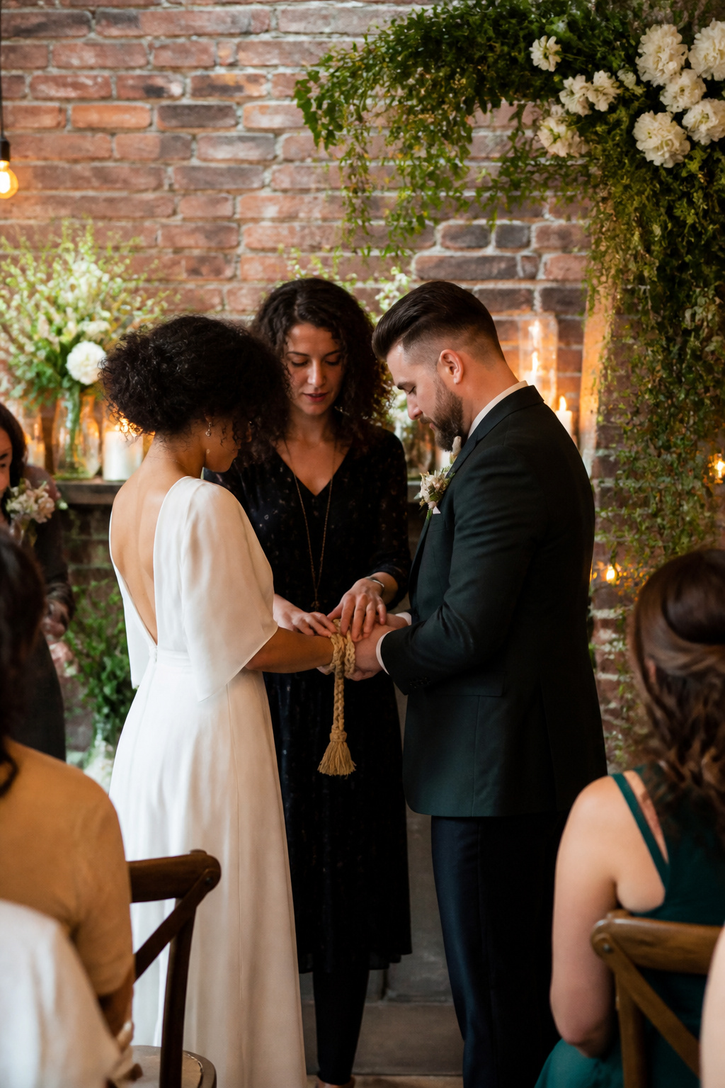 Couple in a stylish urban setting with hands bound by a designer cord.