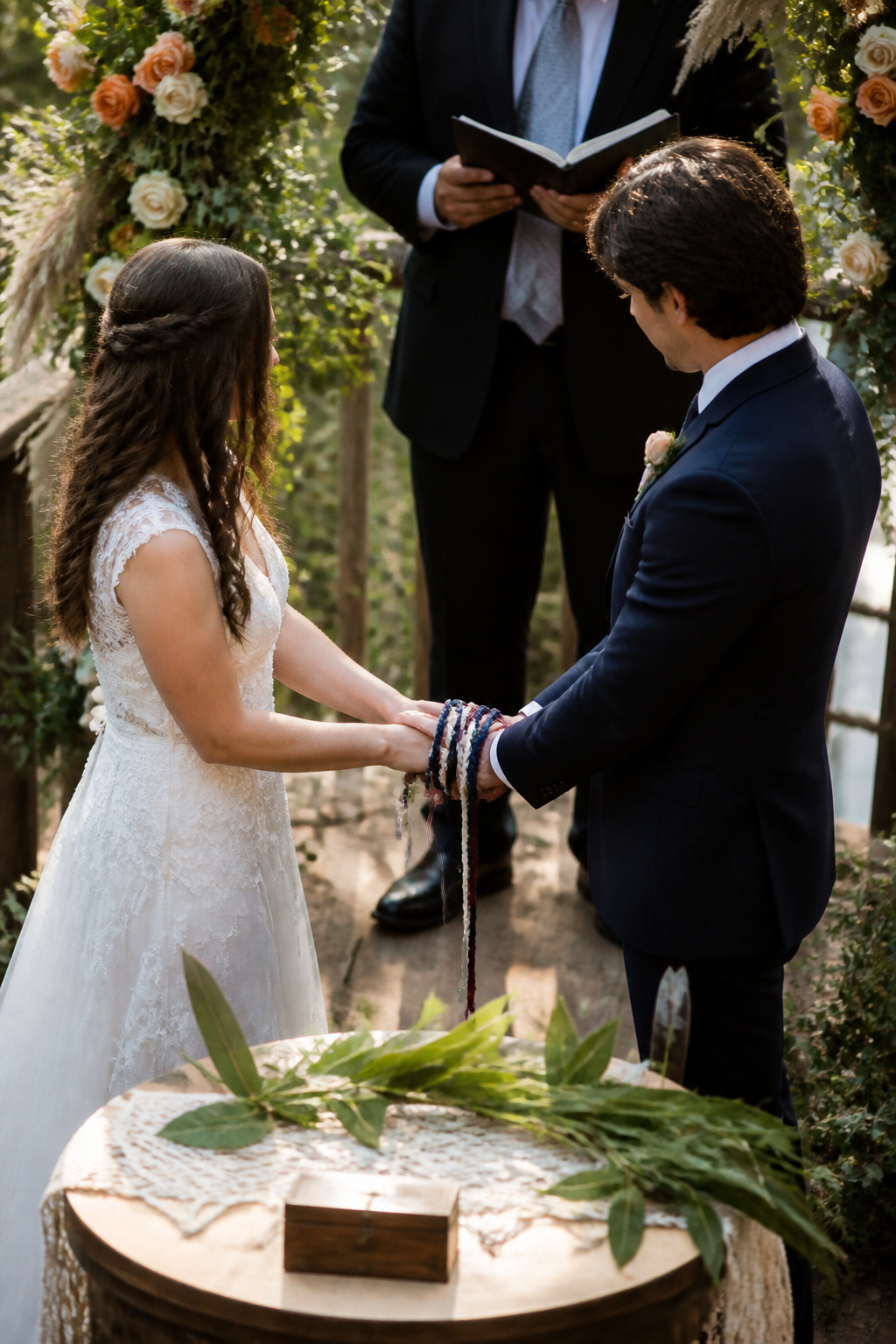 Couple exchanging vows while the cord is being wrapped around their hands.