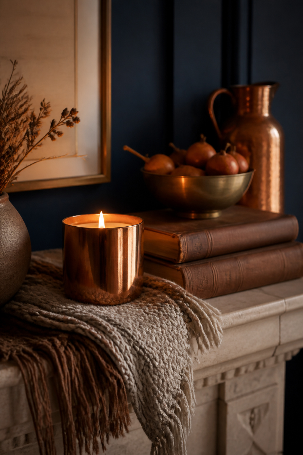 23 Chic Fall Decor Ideas for an Elevated 2026 Season 6 A copper candle surrounded by textiles and decor on a mantel.