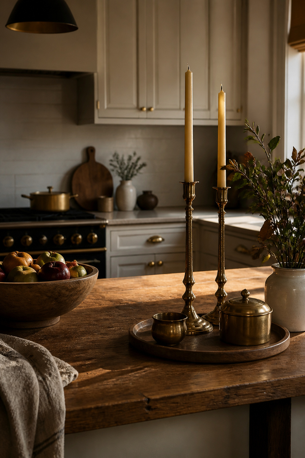 Brass candlesticks and wooden bowls on a kitchen counter.