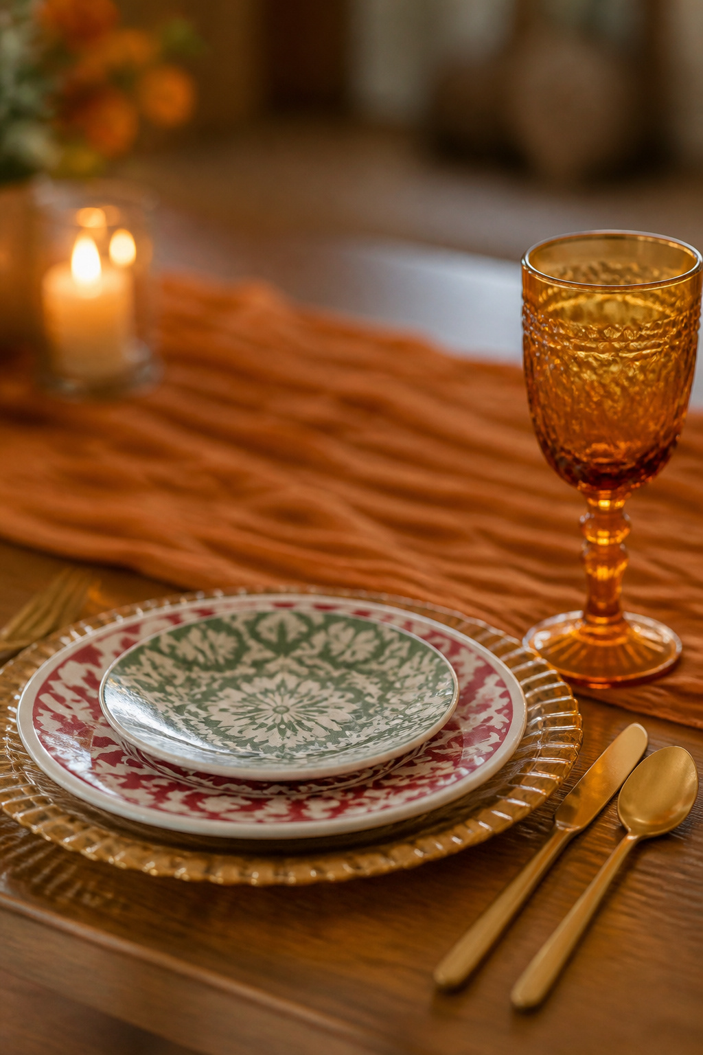A wedding table with colored glassware and decorative chargers.