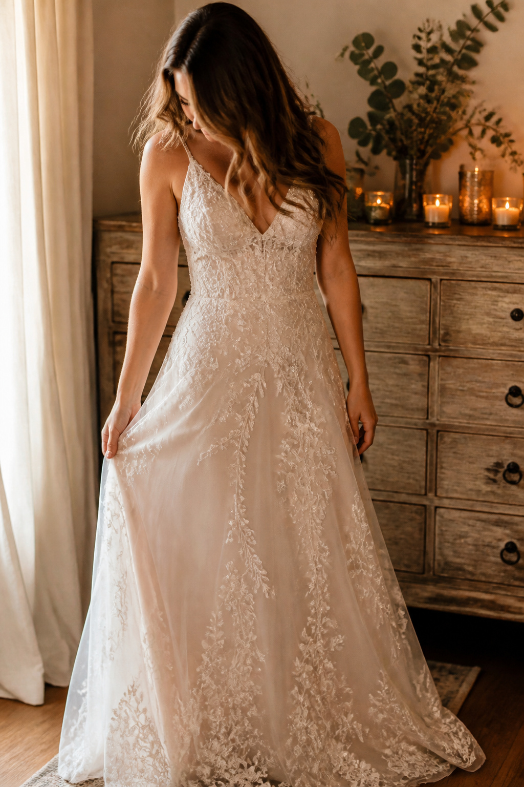 A bride in an intricately embroidered wedding dress indoors.