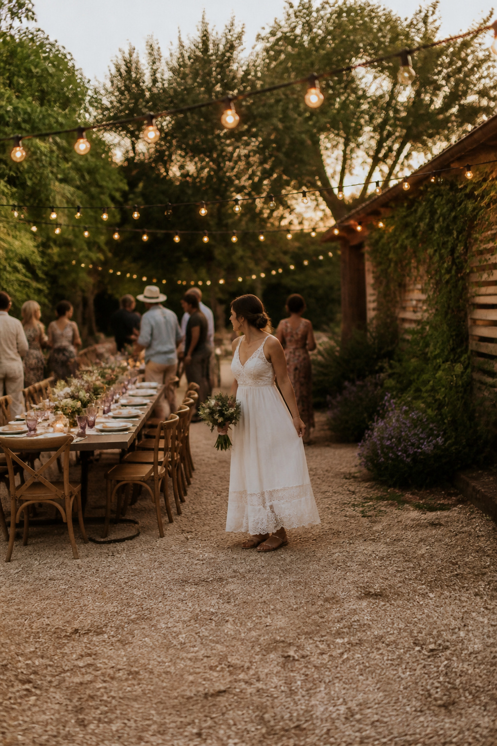 A bride wearing a casual sundress-style wedding dress outdoors.