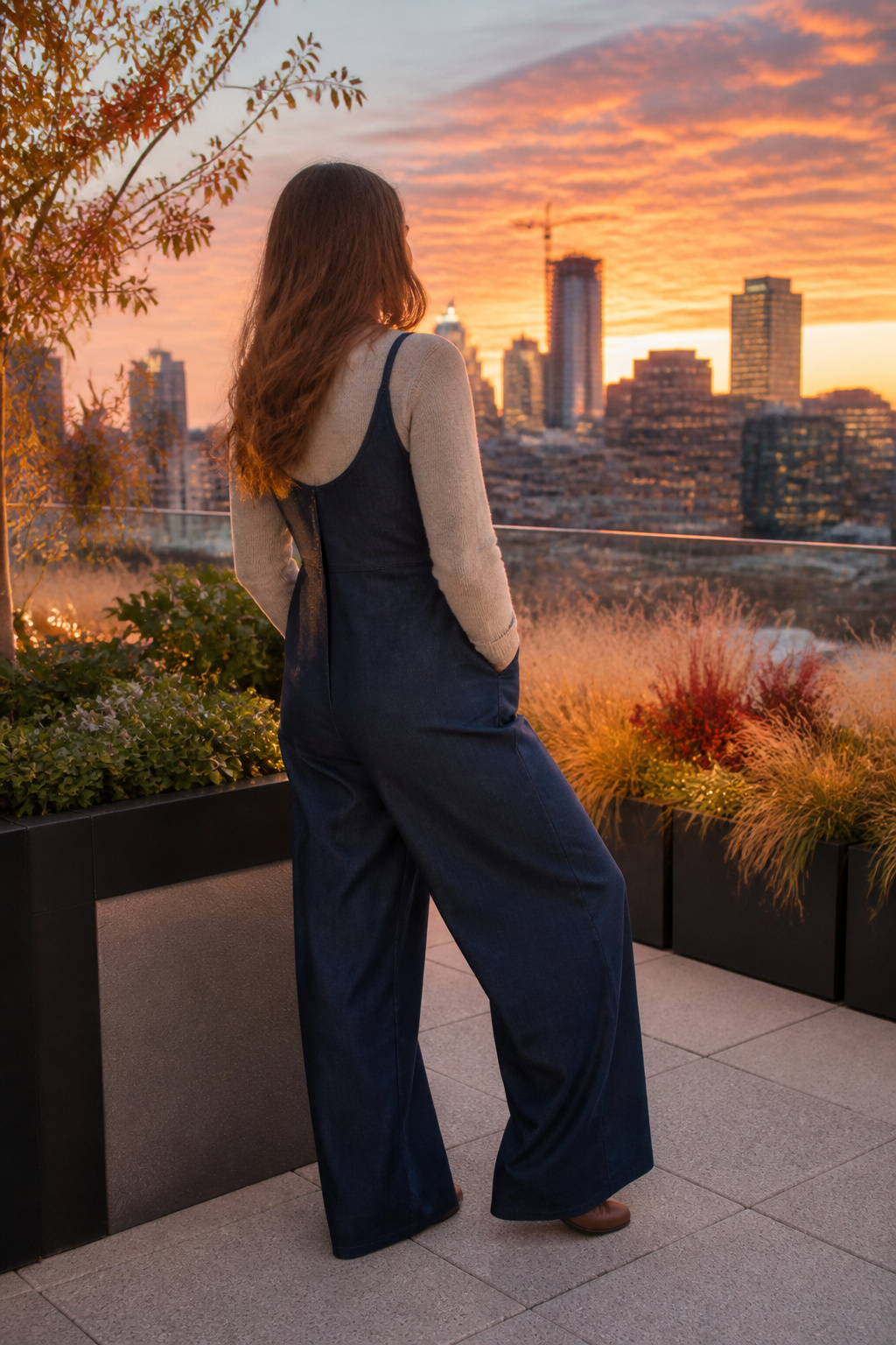 Model in a wide-leg jumpsuit on a rooftop during sunset.