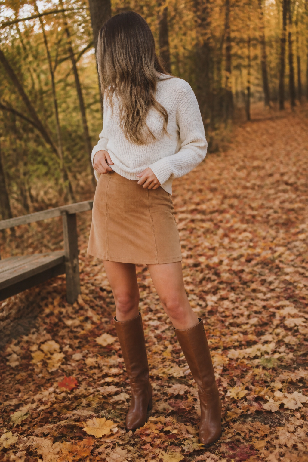 10 Fall Skirt Outfit Ideas for 2026 5 Model wearing a suede skirt and chunky sweater in autumn.